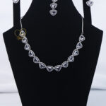ALIRE JEWELS Heart Shaped White Crystal Necklace Set with silver plating, matching earrings and maang tikka