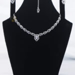 ALIRE JEWELS Elegant Linked Crystal Necklace Set with silver plating, matching earrings and maang tikka